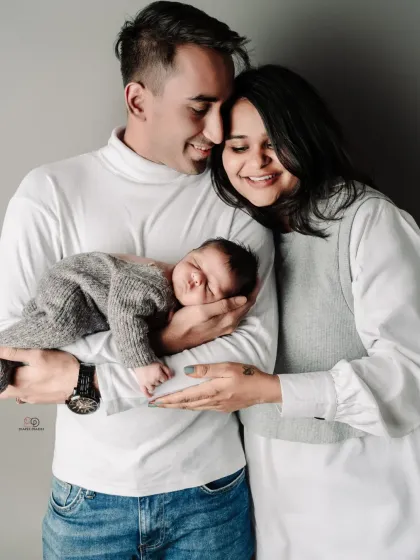Another beautiful pose from the same session. The coordinated white and grey outfits create a clean and modern look for this new family of three.