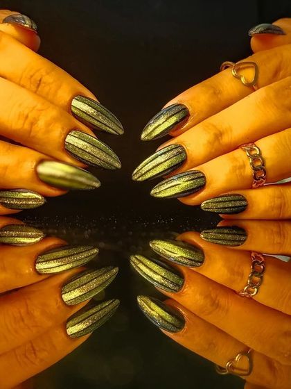 A full view of the edgy green and black striped cat-eye manicure.