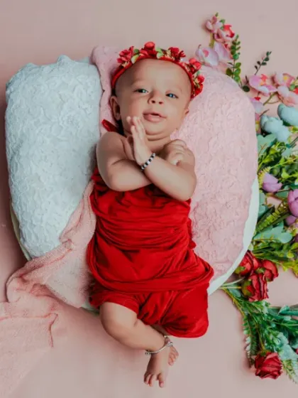 Three months of sunshine. This older baby is awake and alert, showing off his personality in this fun, red-themed milestone shoot.