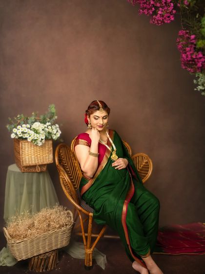 A graceful portrait of an expectant mother in a traditional green saree. The classic pose and earthy studio backdrop highlight her elegance and the beauty of our heritage.