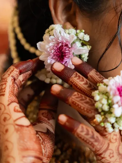 A detailed shot of the baby shower mehendi, showing the delicate patterns on the fingers and the rich, dark stain of the henna.