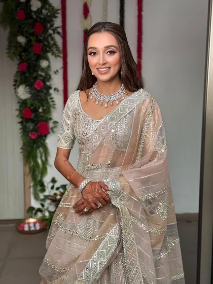 The beautiful bride-to-be, seen from the front. Her half-up hairstyle keeps the hair away from her face, allowing her radiant smile and stunning diamond necklace to take center stage.