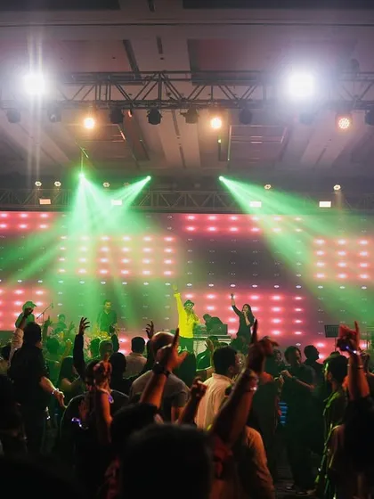 The view from the stage at a corporate event. A packed room, hands in the air, and incredible lighting. This is the concert experience we bring to every client.