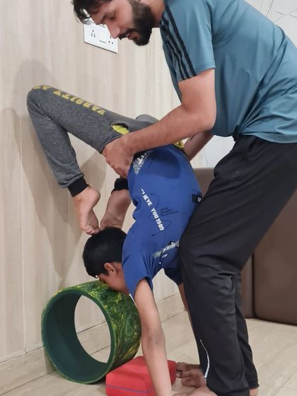 With careful guidance, we help children explore more advanced poses. This assisted backbend helps improve spinal flexibility and body awareness, always ensuring the child feels secure and supported by the instructor.