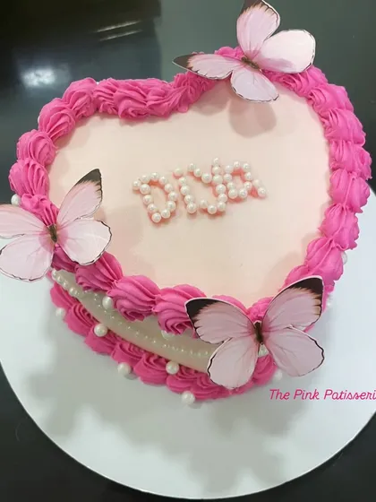 A heart-shaped cake for Diva, featuring pink buttercream piping and three beautiful butterflies.