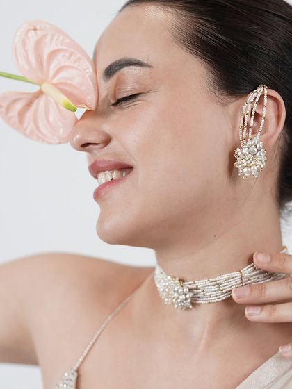 A beautiful model shot showcasing our white floral earcuff and choker set, a truly iconic style.
