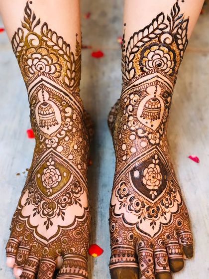 A gorgeous foot design with jhumka and floral motifs, scattered with delicate rose petals.