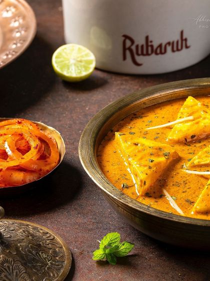 A styled shot of the Paneer-e-Rubaruh with laccha onions and lime, suggesting accompaniments.