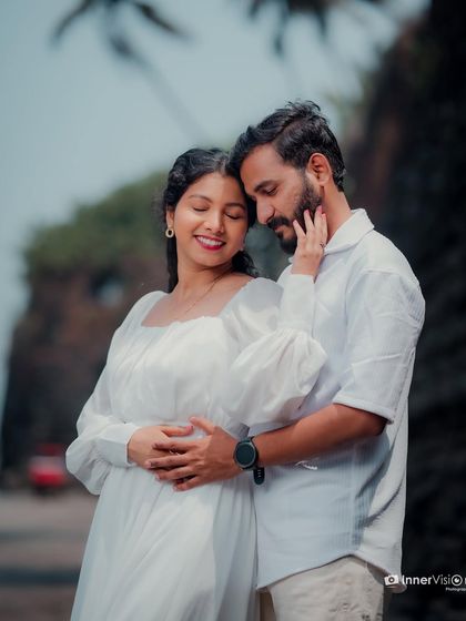 A tender embrace with the bride-to-be gently touching her partner's face. Their closed eyes and soft smiles convey a deep sense of love and contentment.