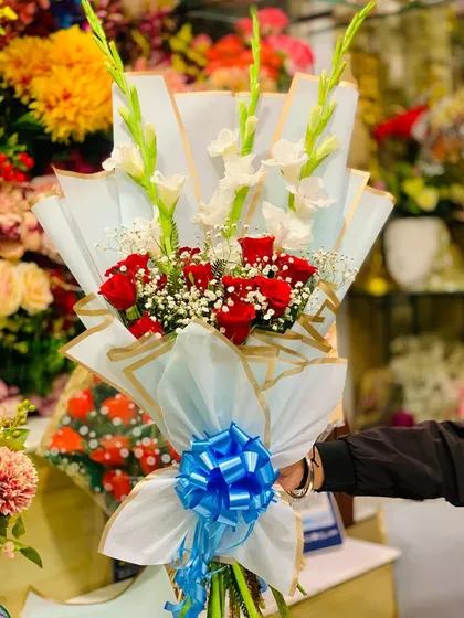 Another angle of the red rose and gladiolus bouquet, showcasing its height and elegant presentation.