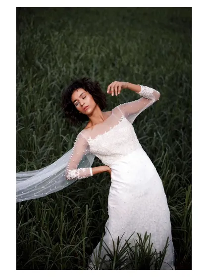 For the bride who wants something different, I love creating editorial-style portraits. This shot, set in a field of tall grass, focuses on the elegant details of the gown and a serene, fashion-forward mood.