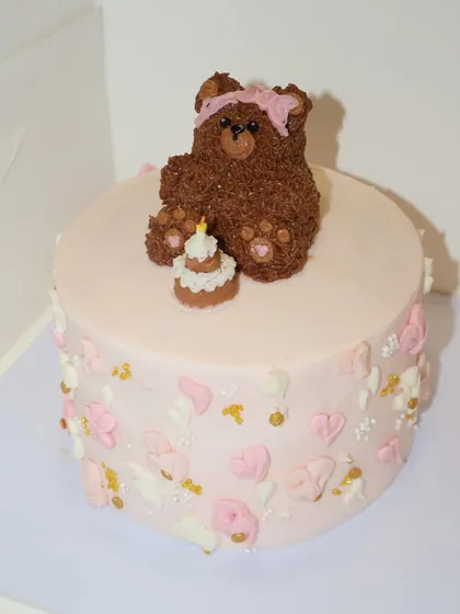 A little cake with a whole lot of cuteness. This design features a hand-piped teddy bear sitting on top of a soft pink cake, complete with its own tiny birthday cake.