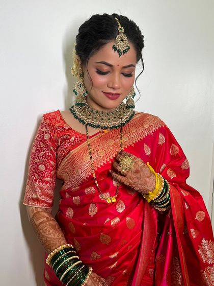 A stunning reception look for Ruchira in a classic red saree with heavy jewellery.