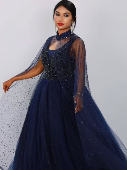 This navy blue ball gown from my JASMIN collection features a fully beaded bodice and a dramatic cape made of sparkling tulle. It's a look of pure, regal elegance.