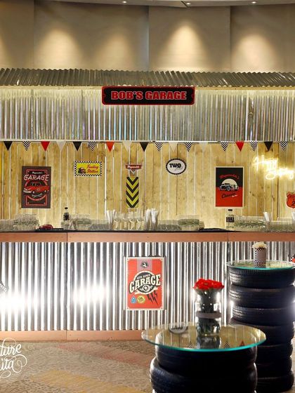 The bar was transformed into 'Bob's Garage' with a corrugated metal front and a wooden backdrop decorated with vintage-style garage signs.