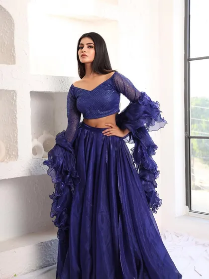 Another shot of the royal blue lehenga, showcasing its vibrant color and modern silhouette against a bright, airy backdrop.