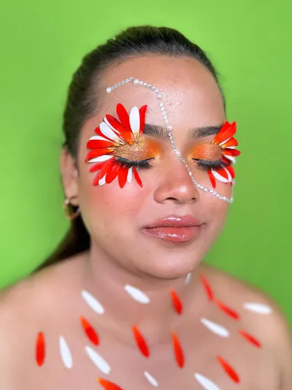 A close-up of the floral makeup with eyes closed, highlighting the vibrant eyeshadow and delicate pearl accents.