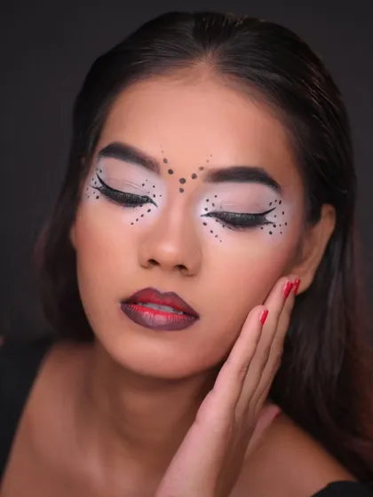 An eyes-closed pose that highlights the symmetry and clean lines of the graphic eye makeup.