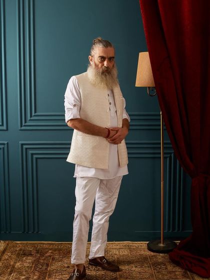 A classic all-white look, elevated by a textured, self-patterned vest. This ensemble is the epitome of classy, comfortable, and timeless festive wear.