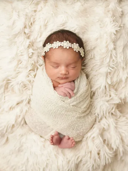 A classic swaddled pose on a soft, fluffy blanket. This technique keeps newborns feeling secure and content, allowing me to capture their serene facial features and tiny toes peeking out.