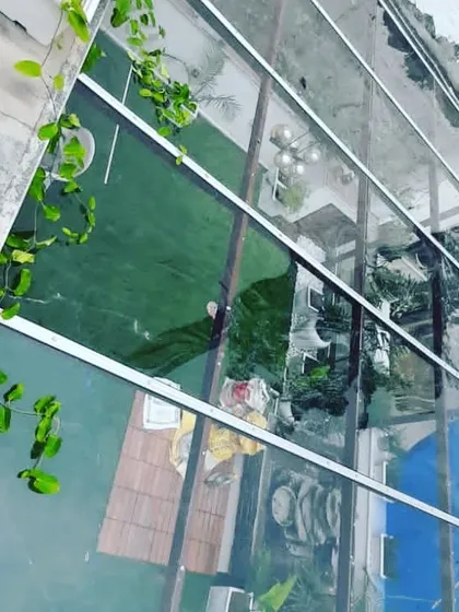 An aerial view of a balcony project during installation, showing the glass roof structure being put into place.