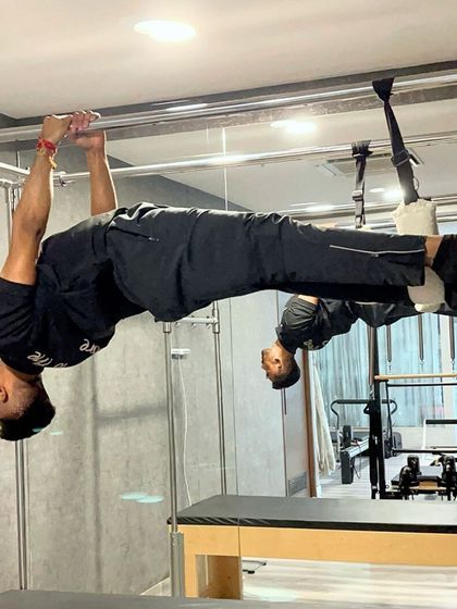 Our trainer demonstrates a full hanging pull up on the Cadillac, a move that requires immense upper body and core strength.