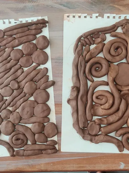 Two different approaches to filling a silhouette with clay. This shows how no two creations are ever alike, even with the same prompt, because each artist brings their own unique perspective.