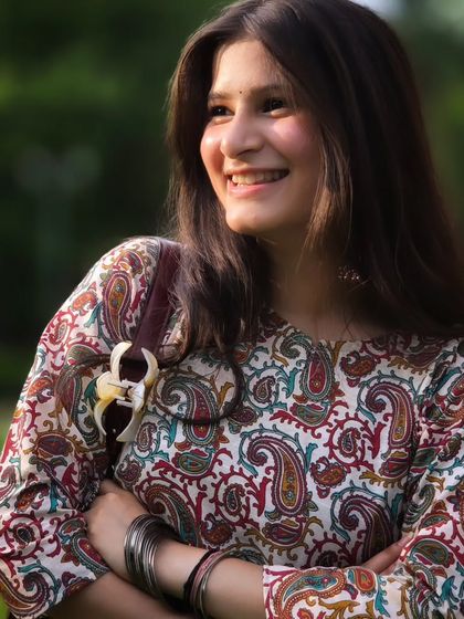 A perfect golden hour portrait. The warm light and her genuine smile create a happy and inviting mood, showcasing a natural and candid moment.