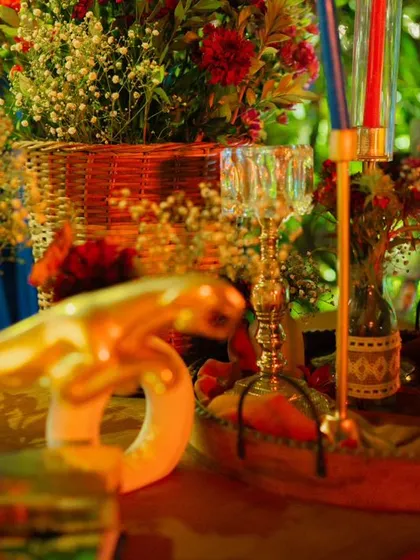 The warm, golden glow of candlelight reflecting off glassware and decor creates an enchanting and intimate atmosphere, perfect for a sophisticated evening.