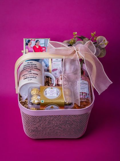 A beautiful birthday hamper curated for a best friend, featuring the personalized mug, a framed photo, chocolates, and pampering items in a stylish pink basket.