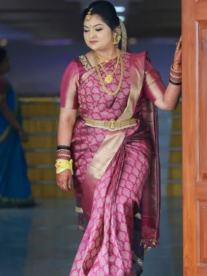 A beautiful bride posing for a photo on her wedding day. Her hair is styled in a traditional updo, a classic and elegant choice for a Muhurtham ceremony.