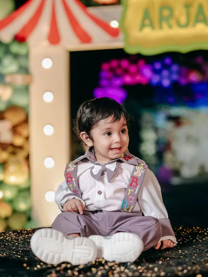 A big, happy smile from the birthday boy at his carnival party. The colorful background and his joyful expression perfectly capture the spirit of the day.