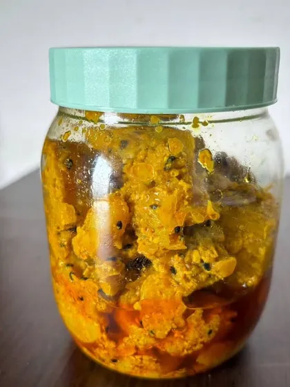 A jar of my tangy amla achar, packed and ready to go. The golden yellow colour comes from turmeric and the blend of spices, with black onion seeds adding to the flavour.