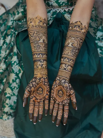 A full view of the bride's hands, covered in a dense and detailed pattern that is perfect for her wedding day.