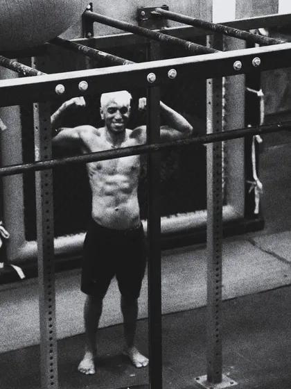 Framed by the rack, a fighter shows the core strength built in our gym. This black and white shot captures the raw, timeless nature of physical training and dedication.