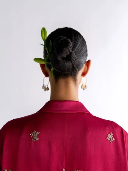 A detail shot from the back for Esha Arora, focusing on the elegant hairstyle and the delicate embroidery on the maroon kurta.
