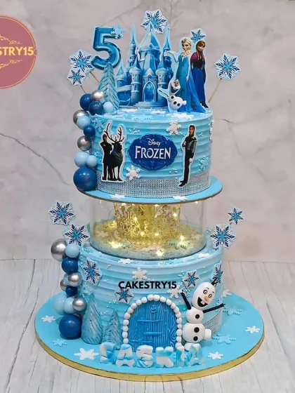 An enchanting two-tier Disney Frozen cake that brings the magic of Arendelle to your party. It features a light-up spacer, a beautiful castle, and characters like Elsa, Anna, and Olaf, all set in a winter wonderland of blue and silver.