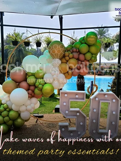 We also specialize in outdoor milestone celebrations. For this 50th anniversary party by the pool, we created a custom circular backdrop with an organic balloon garland in earthy green and brown tones, complemented by large, illuminated marquee numbers.