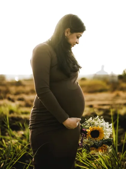 A solo portrait is all about celebrating the mother. Here, the soft, golden light wraps around her, highlighting the beautiful curve of her bump and the serene look of anticipation. It's a powerful, minimalist portrait that radiates strength and grace.