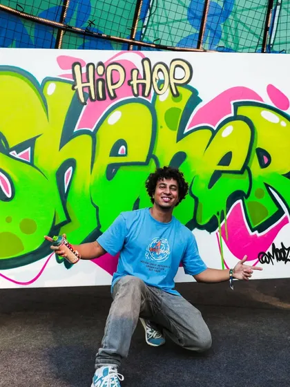 Posing with my finished 'Sheher' graffiti piece at NH7. I love the bright, energetic colors we used for this live performance.