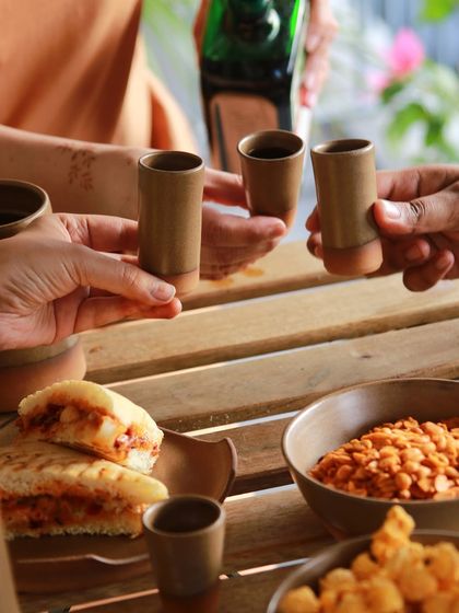 A toast with ceramic shot glasses from the 'Moments Together' collection, capturing the joy and friendship that inspired the work.