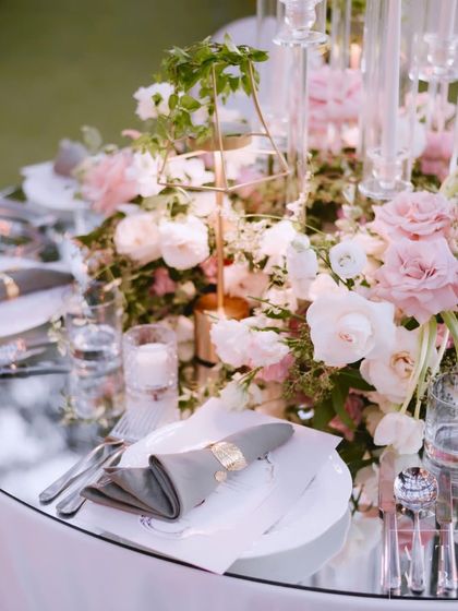 A romantic tablescape from a destination wedding in Bali. The mirrored table reflects the soft florals and candlelight, creating a captivating and magical garden wonderland.