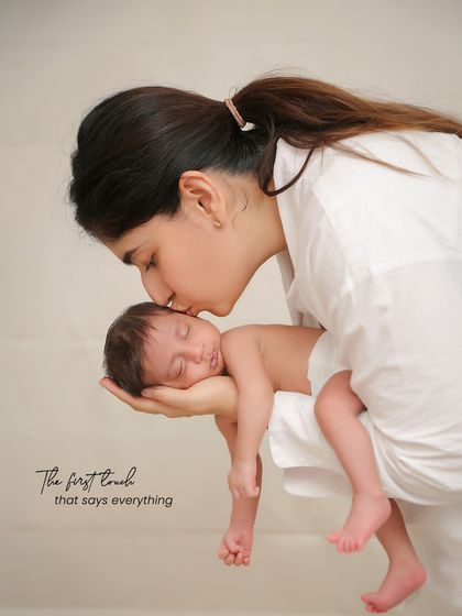 The first touch that says everything. A mother's gentle kiss on her sleeping baby's forehead, a simple and powerful expression of love.