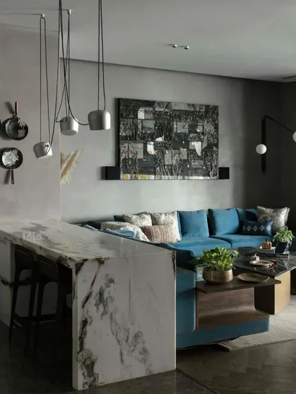 The breakfast counter in the family lounge, made of a striking monolithic piece of marble. The counter is paired with a Flos pendant light and playful wall art, creating a functional and artistic corner.