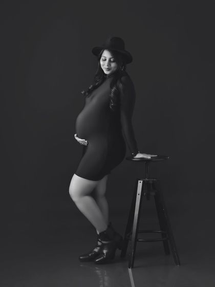 A stylish black and white portrait with the mom-to-be wearing a fedora hat, adding a touch of modern chic.