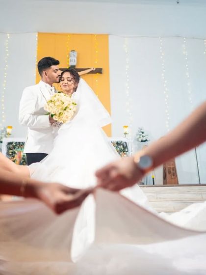 The bridesmaids carefully arrange the bride's train for a photo after the ceremony.