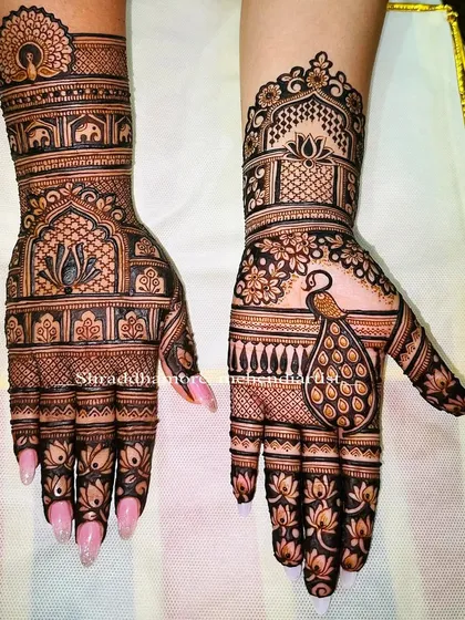 A beautiful example of combining different elements. This design features a peacock on one hand and a lotus in a jharokha on the other, with bands of elephants creating a royal feel.