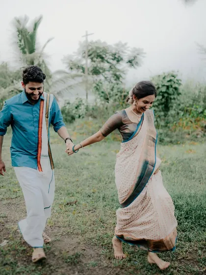 A candid shot of a couple walking hand-in-hand through a field in Alibag. Dressed in traditional attire, their relaxed and joyful interaction shows that cultural photoshoots can be fun and natural, not just formal.