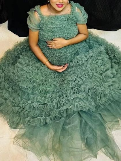 This sage green frill gown is a two-in-one outfit that can be worn as a full gown or a shorter frock, making it a versatile choice for your maternity shoot.