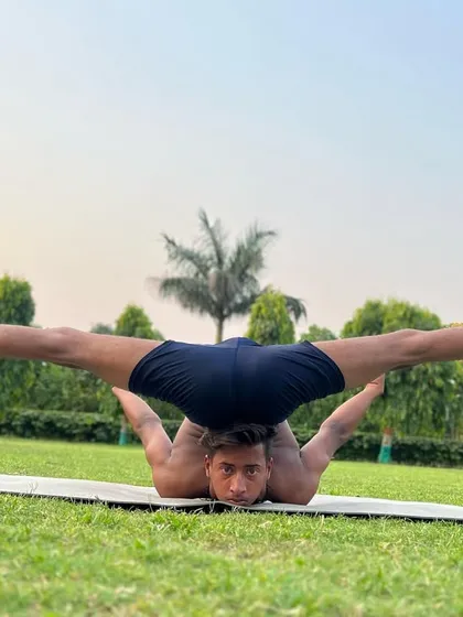 This is what I call over-bending. This pose, a variation of the chin stand, showcases an extreme level of flexibility that we build up to over time.